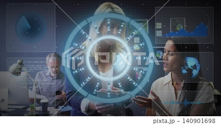 Holding smartphone, central woman wearing navy blazer and white top reviewing AR HUD at office 140901698