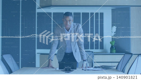 Leaning forward executive directing meeting in boardroom, wearing blazer, with phone and waveform Leaning forward executive directing meeting in boardroom, wearing blazer, with phone and waveform 140901821