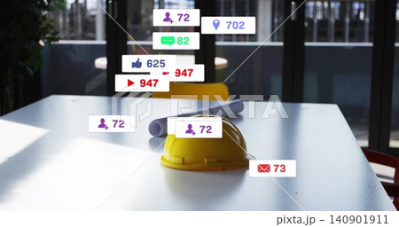 Resting yellow construction hard hat centered on white conference table, with blueprints and badges 140901911