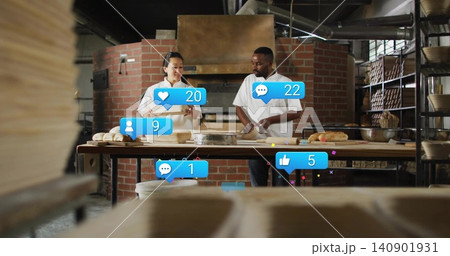 Shaping dough, two bakers in aprons handling loaves at bakery worktable with social media overlays Shaping dough, two bakers in aprons handling loaves at bakery worktable with social media overlays 140901931