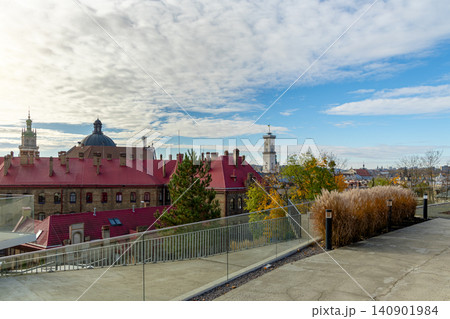A panoramic view of an old European city featuring terracotta rooftops, architectural landmarks, and lush greenery under a cloudy sky A panoramic view of an old European city featuring terracotta rooftops, architectural landmarks, and lush greenery under a cloudy sky 140901984