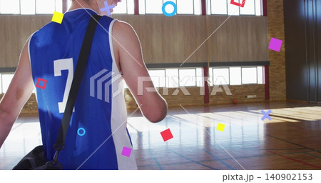 Walking adult male wearing blue number 7 jersey carrying black bag on hardwood court, copy space 140902153