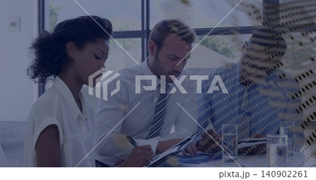 Reviewing three professionals in business attire taking notes in meeting room, with charts and pens Reviewing three professionals in business attire taking notes in meeting room, with charts and pens 140902261