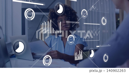 Reviewing analyst in blue blouse and glasses holding documents in conference, with laptop overlays Reviewing analyst in blue blouse and glasses holding documents in conference, with laptop overlays 140902263