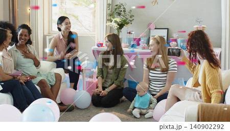 Gathering women sitting at home around infant wearing bib and holding smartphone, pastel balloons Gathering women sitting at home around infant wearing bib and holding smartphone, pastel balloons 140902292