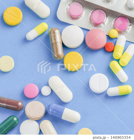 Seamless pattern of colorful medical pills capsules and tablets flat lay on blue background Seamless pattern of colorful medical pills capsules and tablets flat lay on blue background 140903354