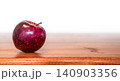 Vibrant Red Apple lying on the left side of a warm wooden surface with copy space 140903356