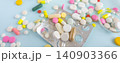 Top view of colorful medical pills, capsules, and tablets spilled on bright yellow background 140903366