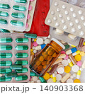 Top view of various colorful medical capsules, tablets, and dark glass bottles in chaos 140903368