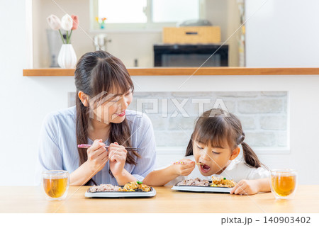 宅配弁当を笑顔で楽しむ親子 健康的な食生活のイメージ 140903402