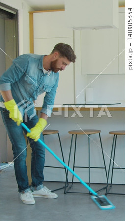 Vertical Video Man is mopping floor at home and having fun. Man, joy and houses concept. Vertical Video Man is mopping floor at home and having fun. Man, joy and houses concept. 140905354