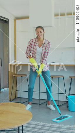 Vertical Video Young woman singing and dancing while cleaning her house. Vertical Video Young woman singing and dancing while cleaning her house. 140905408