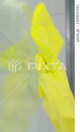 Vertical Video Girl removing cleaning solution from glass with special tool, cleaning service. Vertical Video Girl removing cleaning solution from glass with special tool, cleaning service. 140905481