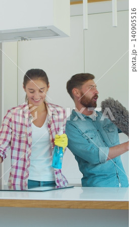 Vertical Video Man and woman as a professional cleaners in uniiform having fun during the work on the kitchen. Vertical Video Man and woman as a professional cleaners in uniiform having fun during the work on the kitchen. 140905516
