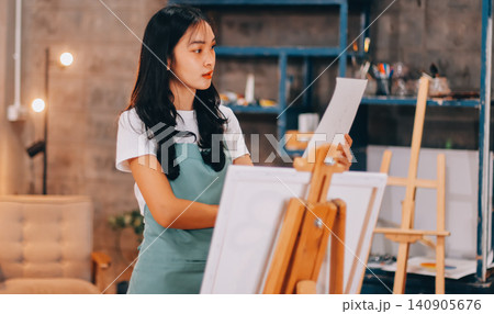 Female artist wears black hat posing near picture indoor the studio 140905676