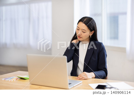 明るい窓辺でパソコンで作業しながら肩に触れて痛そうな若い日本人ビジネスウーマン 明るい窓辺でパソコンで作業しながら肩に触れて痛そうな若い日本人ビジネスウーマン 140906114