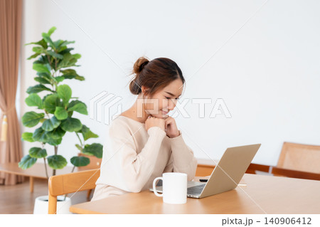 Beautiful young Asian woman working with laptop computer in living room. Work at home Beautiful young Asian woman working with laptop computer in living room. Work at home 140906412