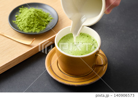 抹茶ラテをカップに注ぐ 140906573