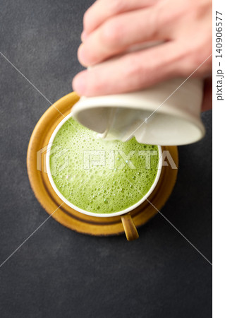 抹茶ラテをカップに注ぐ 抹茶ラテをカップに注ぐ 140906577