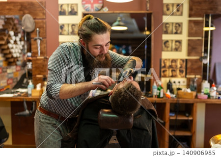 Straight razor trimming on customer face in the barbershop 140906985