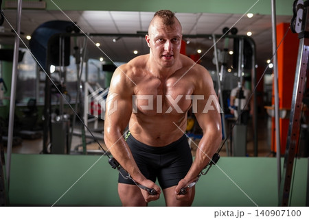 Muscular bodybuilder doing cable crossover chest flyes Muscular bodybuilder doing cable crossover chest flyes 140907100