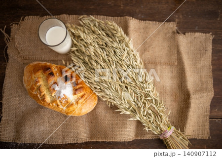Baked bread loaf served with a glass of milk 140907112