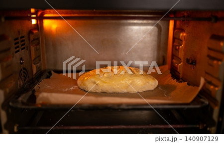 Scored bread loaf baking inside a hot oven 140907129