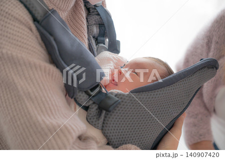 抱っこ紐の中で見上げる赤ちゃん 抱っこ紐の中で見上げる赤ちゃん 140907420