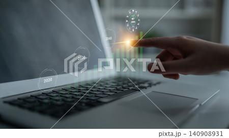Hand Interacting with Touch Screen Display to Analyze Data Trends and Projections on Laptop in Modern Workspace Environment Gantry 140908931