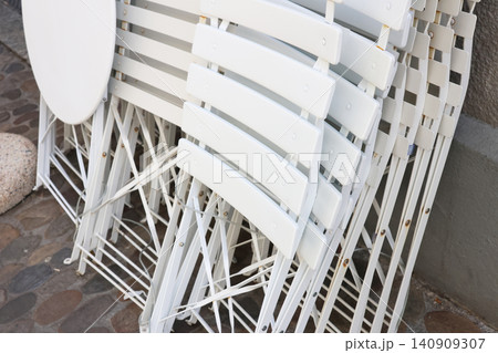 Stacked White Folding Chairs and Tables for Outdoor Event Setup Stacked White Folding Chairs and Tables for Outdoor Event Setup 140909307