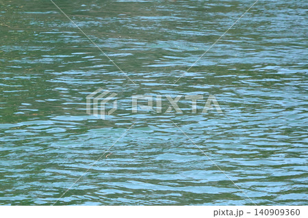 Tranquil Water Surface with Gentle Ripples for Nature Background Design Tranquil Water Surface with Gentle Ripples for Nature Background Design 140909360
