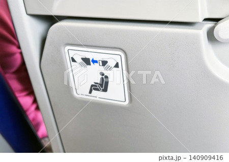 Airplane Safety Instruction Sign with Folding Tray Table in Focus for In-Flight Guidance and Passenger Safety Airplane Safety Instruction Sign with Folding Tray Table in Focus for In-Flight Guidance and Passenger Safety 140909416