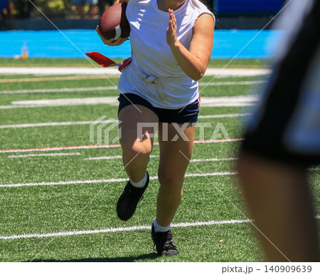 Flag Football Game in Action With Player Running on Field Flag Football Game in Action With Player Running on Field 140909639