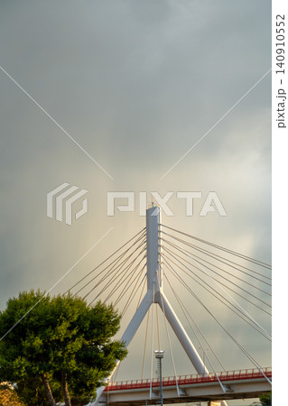 Low angle view of modern bridge pylon against cloudy sky Low angle view of modern bridge pylon against cloudy sky 140910552