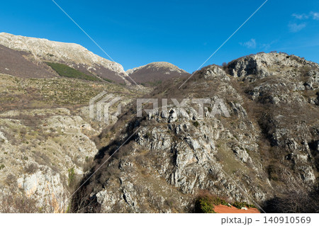 Rugged limestone rock formations under blue sky in Apennines mountains Rugged limestone rock formations under blue sky in Apennines mountains 140910569