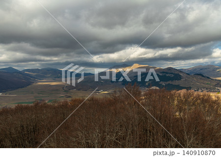 High angle view of a wide mountain valley under cloudy sky in Abruzzo region 140910870