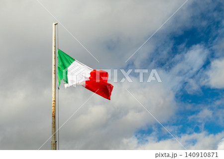 Italian flag waving on flagpole against cloudy sky 140910871
