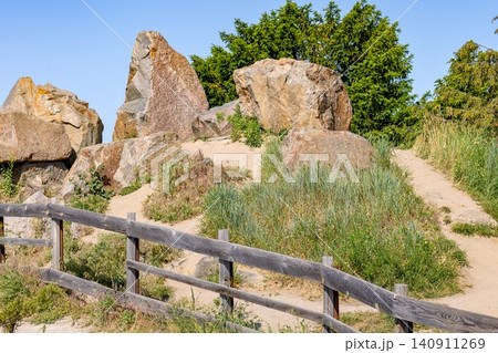 Rocks and plants along a sandy path in a park on a sunny day Rocks and plants along a sandy path in a park on a sunny day 140911269