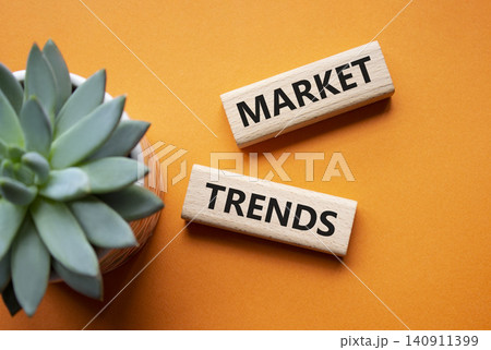 MARKET TRENDS symbol. Concept word MARKET TRENDS on wooden blocks. Beautiful orange background with succulent plant. Business and MARKET TRENDS concept. Copy space 140911399