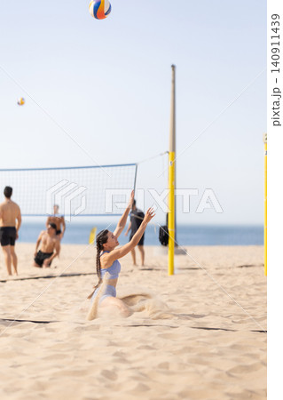 Beach volleyball game takes place on sunny day with players enjoying the sand and sea Beach volleyball game takes place on sunny day with players enjoying the sand and sea 140911439