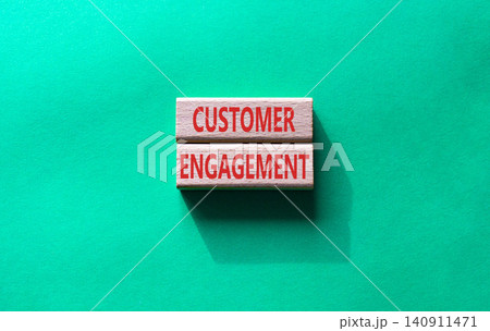 Customer engagement symbol. Concept word Customer engagement on wooden blocks. Businessman hand. Beautiful blue background. Business and Customer engagement concept. Copy space Customer engagement symbol. Concept word Customer engagement on wooden blocks. Businessman hand. Beautiful blue background. Business and Customer engagement concept. Copy space 140911471
