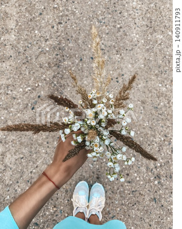 Wildflower Bouquet Held by Hand on Sandy Path from Above Wildflower Bouquet Held by Hand on Sandy Path from Above 140911793