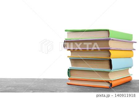 Stack of colorful books on grey stone table against white background Stack of colorful books on grey stone table against white background 140911918