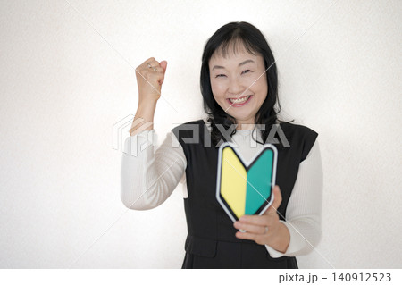 初心者マークを持ってガッツポーズする女性 初心者マークを持ってガッツポーズする女性 140912523