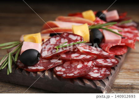Tasty ham with other delicacies served on wooden table, closeup Tasty ham with other delicacies served on wooden table, closeup 140912693