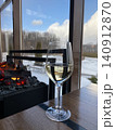 Glass of White Wine by Fireplace with Winter View 140912870