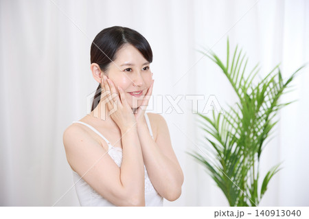スキンケア後の肌に満足して微笑む女性 スキンケア後の肌に満足して微笑む女性 140913040