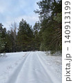 Snow Covered Forest Road Through Pine Trees in Winter 140913199