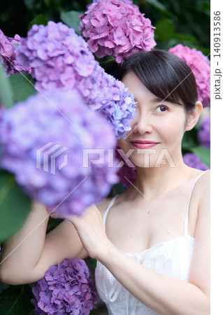 紫陽花に包まれ穏やかな表情を見せる女性 140913586