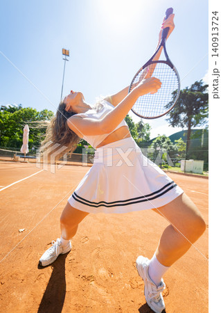 Woman athlete playing tennis on clay court 140913724